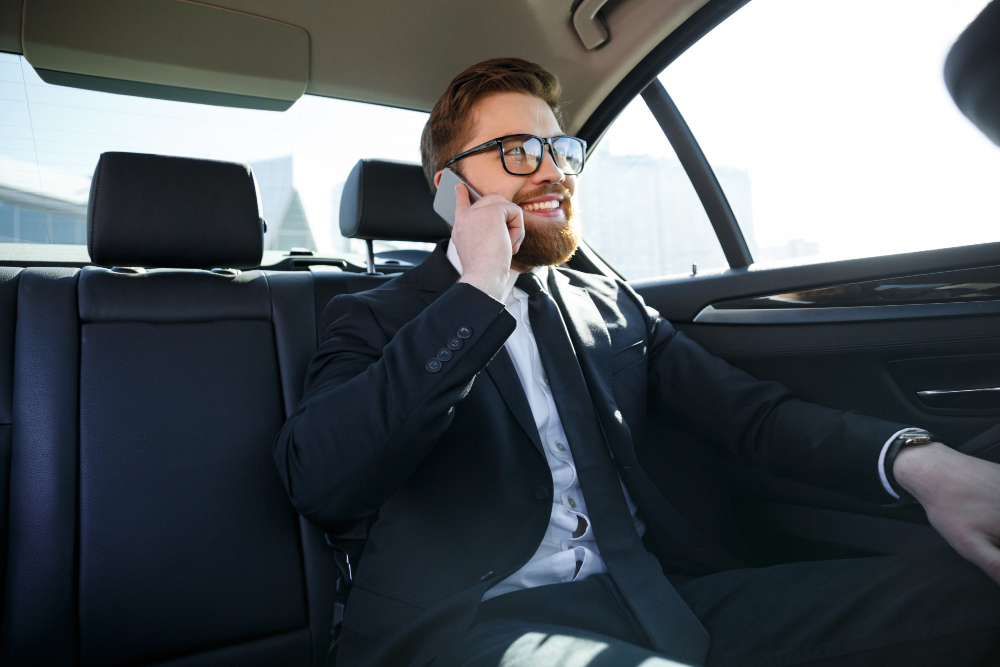 Homem feliz falando no celular dentro carro